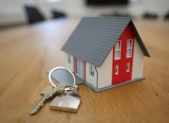 white and red wooden house miniature on brown table